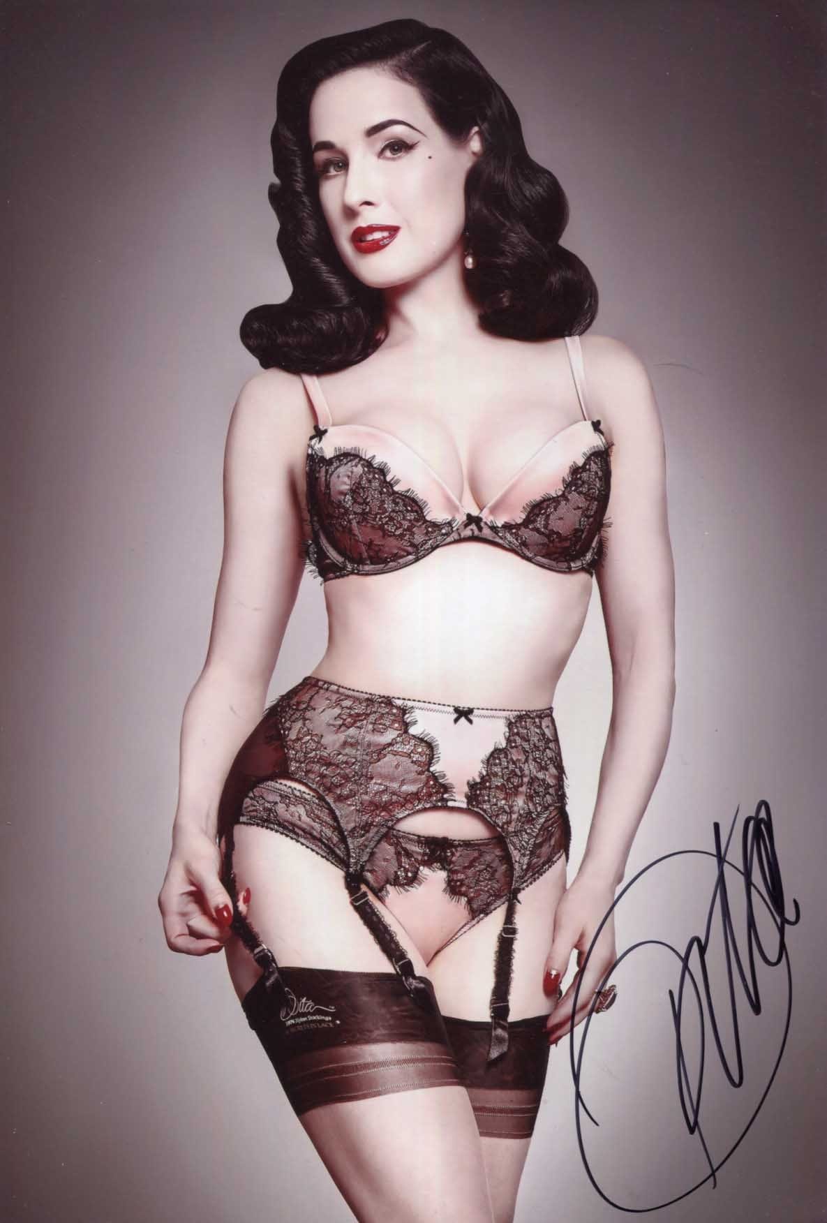 was für note ist befriedigend Dita Von Teese stands in the spotlight wearing Madame X red suspenders main image 1